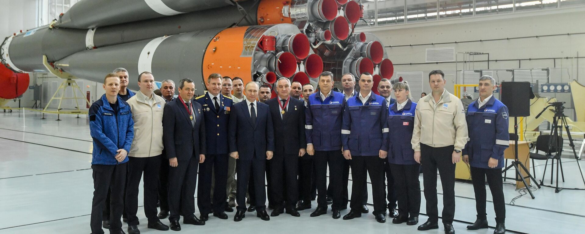  صورة جماعية للرئيس الروسي فلاديمير بوتين مع عمال فيقاعدة  فوستوشني الفضائية في ورشة تجميع مركبات الإطلاق. في الصف الأول، الثالث من اليسار: أوليغ سكريبوتشكا، المتخصص الرائد في مركز يو إيه غاغارين للبحوث والتدريب، حصل على وسام الاستحقاق للوطن، الدرجة الثالثة، الرابعة من اليسار: رائد فضاء يختبر يو. . مركز غاغارين للتدريب على البحث والاختبار غاغارين سيرغي بروكوبييف، مُنح لقب بطل الاتحاد الروسي واللقب الفخري لرائد فضاء طيار من روسيا الاتحادية، السادس من اليسار: المدرب - رائد الفضاء - ألكسندر سكفورتسوف من غاغارين للأبحاث والاختبار. مركز التدريب الحاصل على وسام الاستحقاق للوطن من الدرجة الثالثة. - سبوتنيك عربي, 1920, 13.09.2025