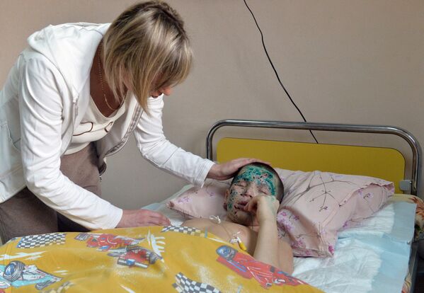فانيا فورونوف (9 سنوات) مع والدته، في جناح الإصابات الخطيرة بمعهد أبحاث الطوارئ وجراحة الأطفال والكسور في موسكو.تلقى فانيا فورونوف إصابات بالغة إثر انفجار قذيفة في شاختورسك في منطقة دونيتسك. فقد الصبي نظره، ذراعه، وساقيه. في عام 2015، تم نقله إلى موسكو لتلقي العلاج. بينما مات تيموفي، أخاه الأصغر منه. - سبوتنيك عربي