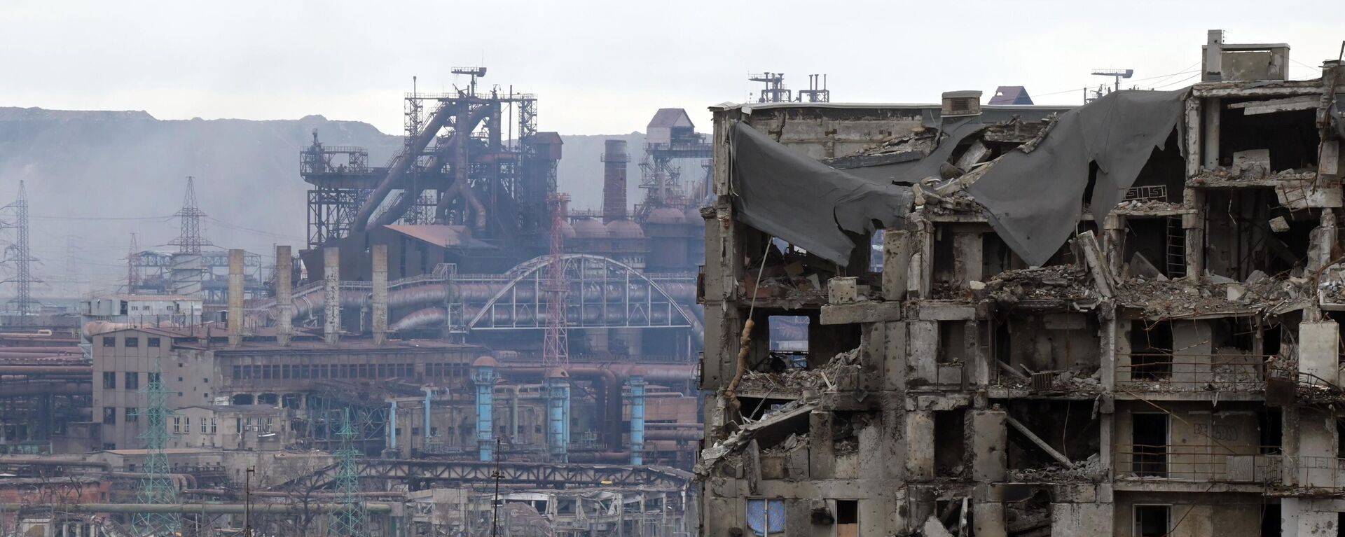 منظر لمبنى سكني مدمر على خلفية مصنع آزوفستال في ماريوبول، أوكرانيا 23 أبريل 2022 - سبوتنيك عربي, 1920, 18.07.2022