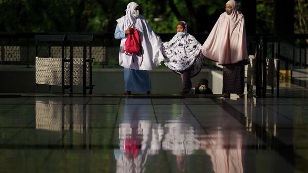 مسلمون يرتدون كمامات يدخلون المسجد الوطني للصلاة في عيد الفطر، في كوالالمبور، ماليزيا 2 مايو 2022. - سبوتنيك عربي