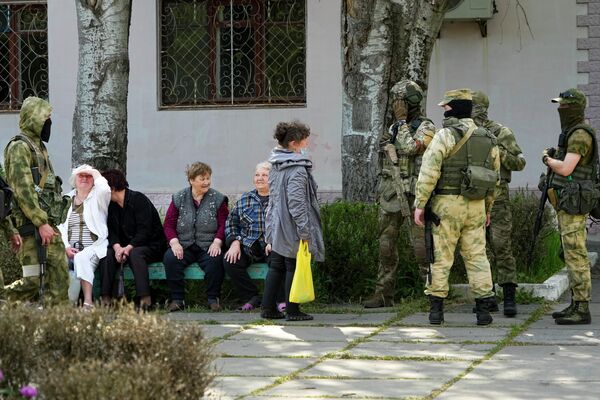كبار السن من السكان المحليين يتحدثون إلى مجموعة من الجنود الروس في خيرسون، منطقة خيرسون، جنوب أوكرانيا، 20 مايو 2022. - سبوتنيك عربي