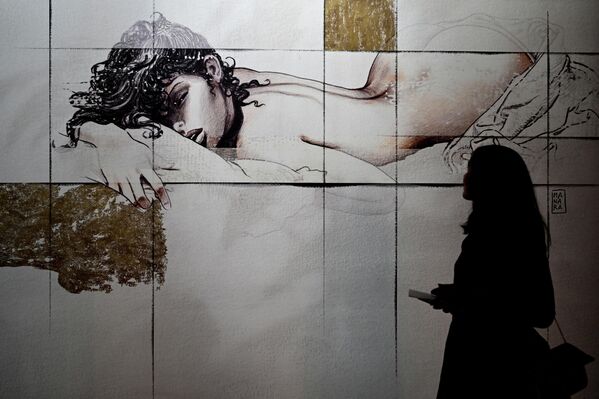 زائرة تنظر إلى لوحة كرتونية من عمل ميلو مانارا (Milo Manara)، في إطار معرض ديزاين فير (Design Fair) في ميلانو، إيطاليا، 7 يونيو 2022. - سبوتنيك عربي