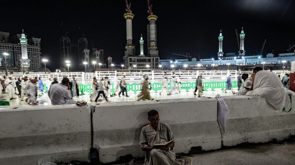 أحد الحجاج يقرأ القرآن على خلفية المسجد الحرام، في مدينة مكة المكرمة في المملكة العربية السعودية في 6 يوليو 2022 - سبوتنيك عربي
