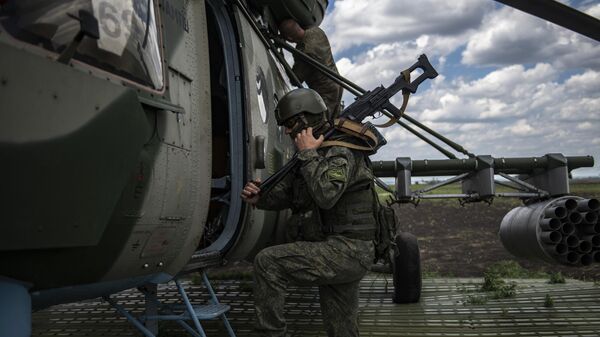 أحد جنود القوات الجوية-الفضائية يدخل مروحية مي-8 ام تي في في مطار ميداني في منطقة العملية العسكرية الخاصة في أوكرانيا - سبوتنيك عربي