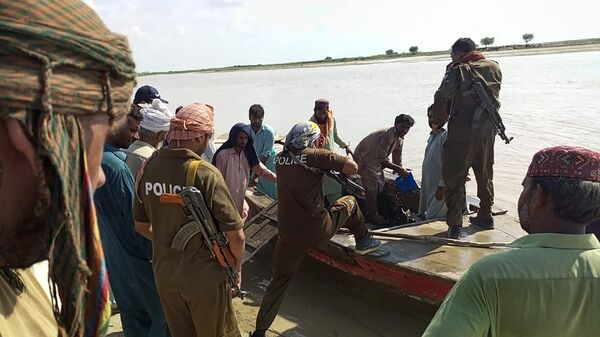 الشرطة الباكستانية وقرويون محليون يساعدون في البحث عن ضحايا قارب غرق في نهر السند وسط باكستان - سبوتنيك عربي