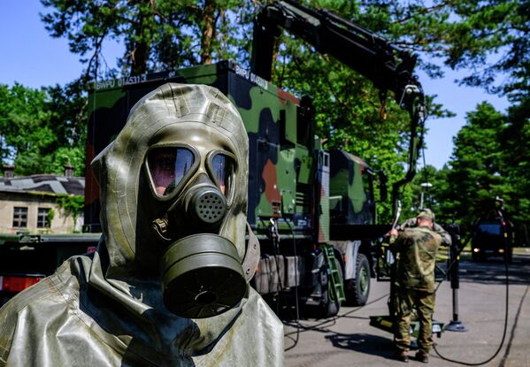 أعضاء في ABC-Abwehrregiment 1 التابع للقوات المسلحة الألمانية، خلال محاكاة عملية إزالة التلوث في مقرهم الرئيسي في شتراوسبرغ، بالقرب من برلين، شرق ألمانيا، في 20 يوليو 2022. - سبوتنيك عربي
