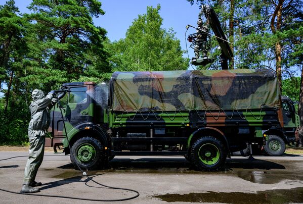 أعضاء في ABC-Abwehrregiment 1 التابع للقوات المسلحة الألمانية، خلال محاكاة عملية إزالة التلوث في مقرهم الرئيسي في شتراوسبرغ، بالقرب من برلين، شرق ألمانيا، في 20 يوليو 2022. - سبوتنيك عربي