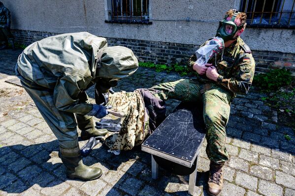 أعضاء في ABC-Abwehrregiment 1 التابع للقوات المسلحة الألمانية، خلال محاكاة عملية إزالة التلوث في مقرهم الرئيسي في شتراوسبرغ، بالقرب من برلين، شرق ألمانيا، في 20 يوليو 2022. - سبوتنيك عربي