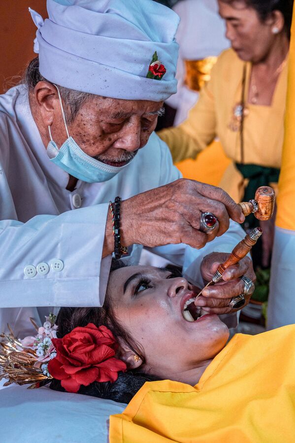 أكثر من مائة من هندوس بالي يشاركون في حفل جماعي لعملية تسوية الأسنان، كرمز للنضج، في معبد جالا سيدي أمرثا في سيدوارجو، 30 يوليو 2022 - سبوتنيك عربي