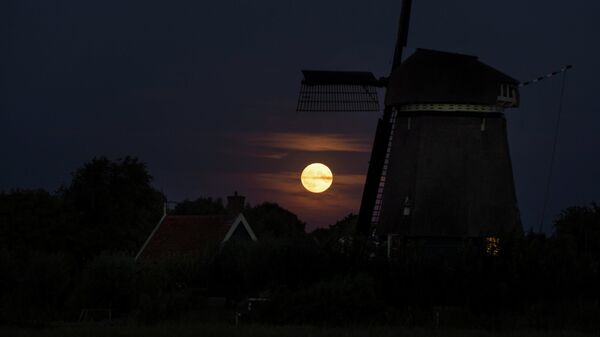 قمر عملاق يرتفع فوق طاحونة هوائية في أوستسان، هولندا 11 أغسطس  2022. - سبوتنيك عربي