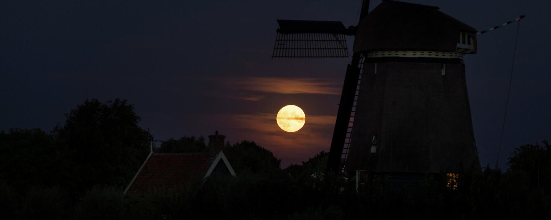 قمر عملاق يرتفع فوق طاحونة هوائية في أوستسان، هولندا 11 أغسطس  2022. - سبوتنيك عربي, 1920, 02.12.2025