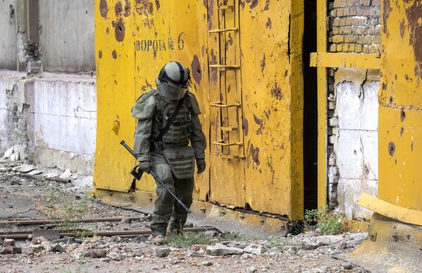 جندي من المركز الدولي للأعمال المتعلقة بإزالة الألغام التابع للقوات المسلحة الروسية يقوم بإزالة الألغام من أراضي مصنع آزوفماش في ماريوبول، 27 أغسطس 2022 - سبوتنيك عربي