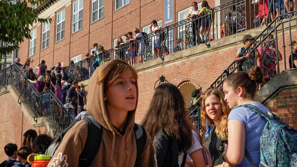 يصطف الطلاب خارج حرم آدامز في مدرسة أويستر آدامز ثنائية اللغة، بينما ينتظرون تسجيل الوصول في اليوم الأول من المدرسة، 29 أغسطس 2022 في واشنطن العاصمة. - سبوتنيك عربي