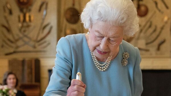ملكة بريطانيا إليزابيث الثانية تقطع كعكة للاحتفال ببدء اليوبيل البلاتيني، في ساندرينجهام هاوس، مقر إقامتها في نورفولك، في ساندرينجهام، إنجلترا، 5 فبراير 2022. - سبوتنيك عربي