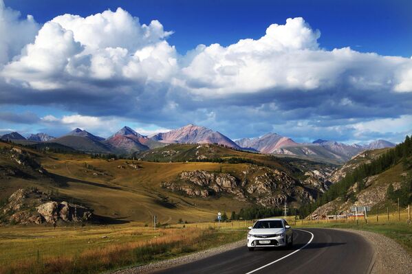سيارة تسير على طول طريق تشويسكي الفيدرالي السريع في جمهورية ألتاي الروسية. أدرجت مجلة ناشونال جيوغرافيك الطريق في قائمة أجمل 10 طرق سريعة في العالم. - سبوتنيك عربي