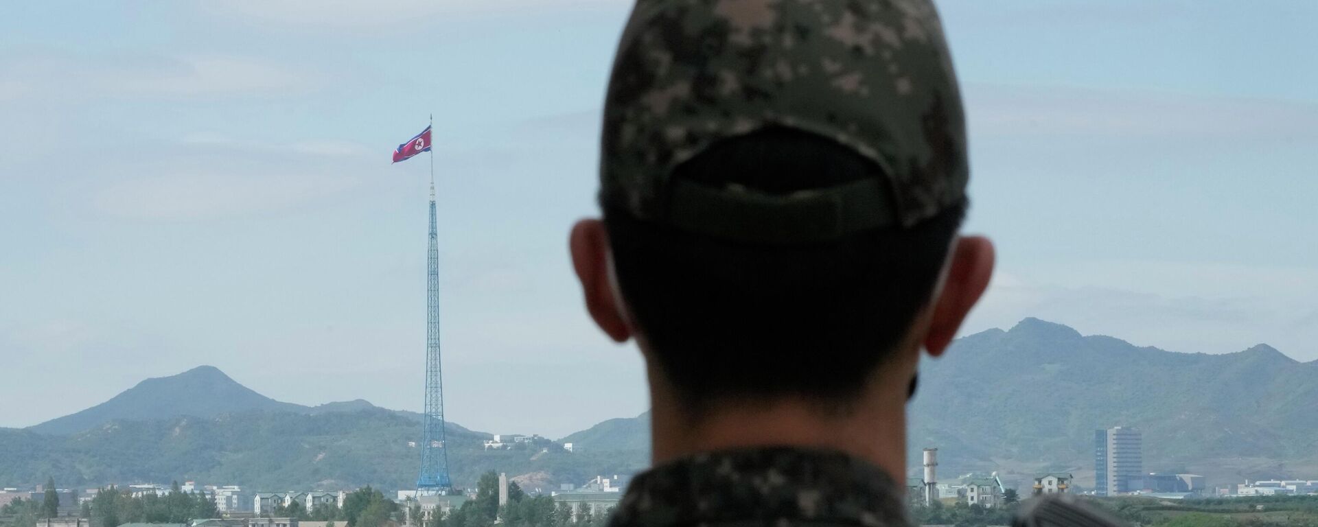 علم كوريا الشمالية يرفرف في مهب الريح بينما يقف جندي من الجيش الكوري الجنوبي في حراسة قرى بانمونجوم الحدودية في باجو، كوريا الجنوبية، 4 أكتوبر 2022. - سبوتنيك عربي, 1920, 29.04.2024
