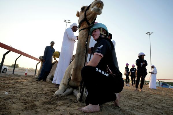 تأخذ المتسابقة النيوزيلندية سارة كولينز لحظة مع أميرها الناقة، قبل السباق الأول لهذا الموسم الذي ينظمه مركز ركوب الجمال الصحراوي العربي في مضمار المرموم لسباق الضاحية بدبي، الإمارات العربية المتحدة، 29 أكتوبر 2022. - سبوتنيك عربي