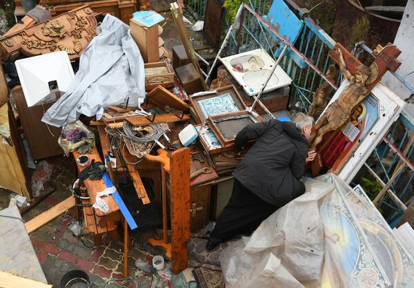 أحد أبناء الرعية على أراضي كنيسة الرقاد المقدس في ماريوبول. أقيمت الخدمة الأولى في كنيسة الرقاد المقدسة المرممة في ماريوبول، 30 أكتوبر 2022 - سبوتنيك عربي