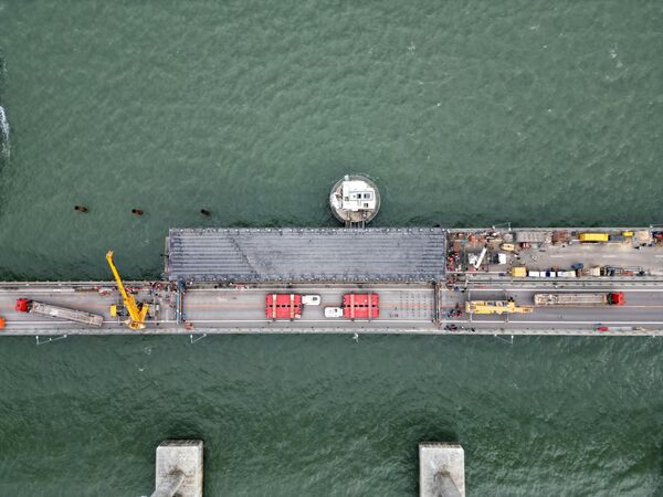 عمال البناء يقومون باستكمال المرحلة الأولى من ترميم الأجزاء المتضررة من مسار الطريق على جسر القرم الروسي. - سبوتنيك عربي