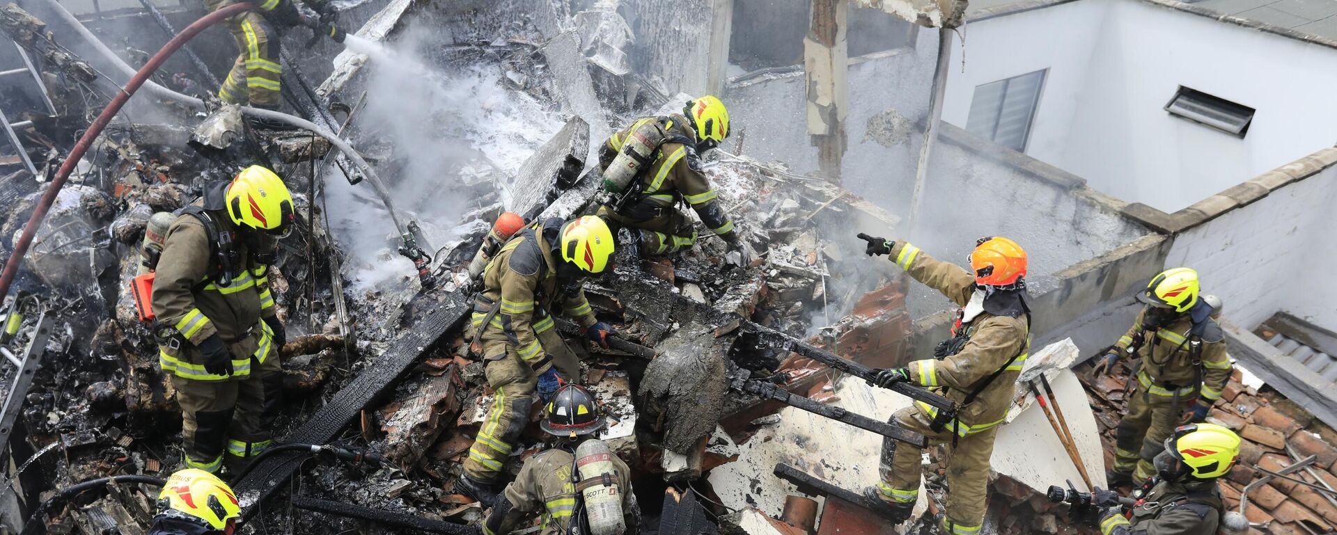 رجال الإطفاء يعملون في موقع تحطم طائرة صغيرة سقطت فوق منازل في منطقة سكنية في ميديلين، كولومبيا، 21 نوفمبر  2022. - سبوتنيك عربي, 1920, 11.04.2025