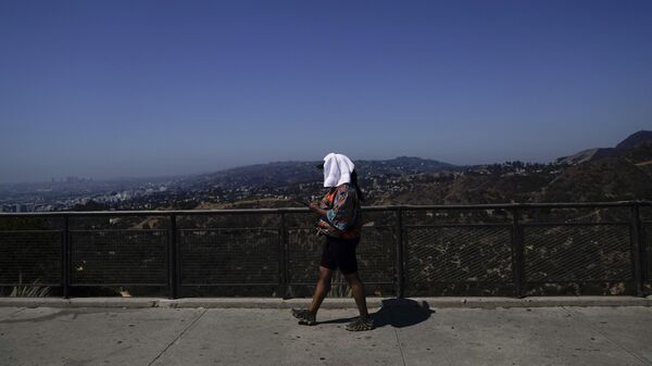 سائحة من جورجيا  تمشي ببرج فوق رأسها في مرصد جريفيث في لوس أنجلوس، 6 سبتمبر 2022، خلال موجة حر. - سبوتنيك عربي