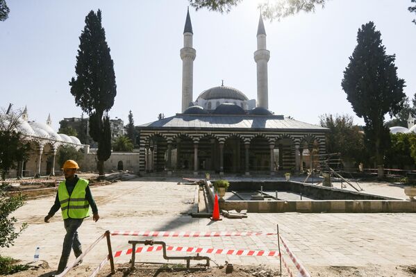 عامل يسير في باحة مجمع جامع السليمانية التكية ، في العاصمة السورية دمشق، في 25 يناير 2023، خلال مشروع ترميم بدأته سلطات البلاد. - سبوتنيك عربي