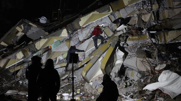 يبحث رجال الإنقاذ عن الضحايا والناجين وسط أنقاض المباني المنهارة في كهرمان ماراش ، تركيا ، بعد زلزال بقوة 7.8 درجة ضرب جنوب شرق البلاد في 7 فبراير 2023. - سبوتنيك عربي