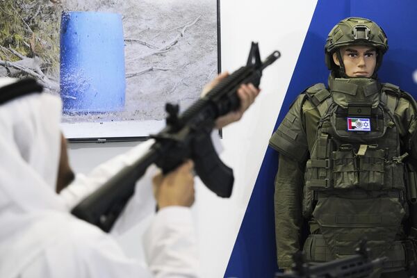إماراتي يتفحص بندقية إسرائيلية في معرض ومؤتمر الدفاع الدولي في أبو ظبي، الإمارات العربية المتحدة،  20 فبراير 2023 - سبوتنيك عربي