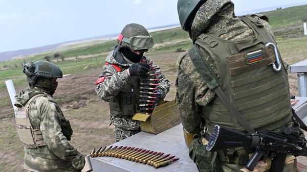 Военнослужащие подразделений ВДВ снаряжают ленты для крупнокалиберного пулемета во время боевой подготовки на полигоне в зоне СВО - سبوتنيك عربي
