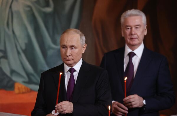 الرئيس الروسي فلاديمير بوتين وعمدة موسكو سيرغي سوبيانين في قداس عيد الفصح في كاتدرائية المسيح المخلص في موسكو، 16 أبريل 2023.  - سبوتنيك عربي