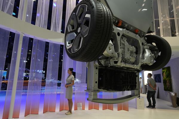 عامل يقف بالقرب من شاشة تعرض أجزاء من السيارة في المركز الوطني للمعارض والمؤتمرات حيث سيُقام معرض شنغهاي الدولي للسيارات 2023 في شنغهاي، 17 أبريل 2023. - سبوتنيك عربي