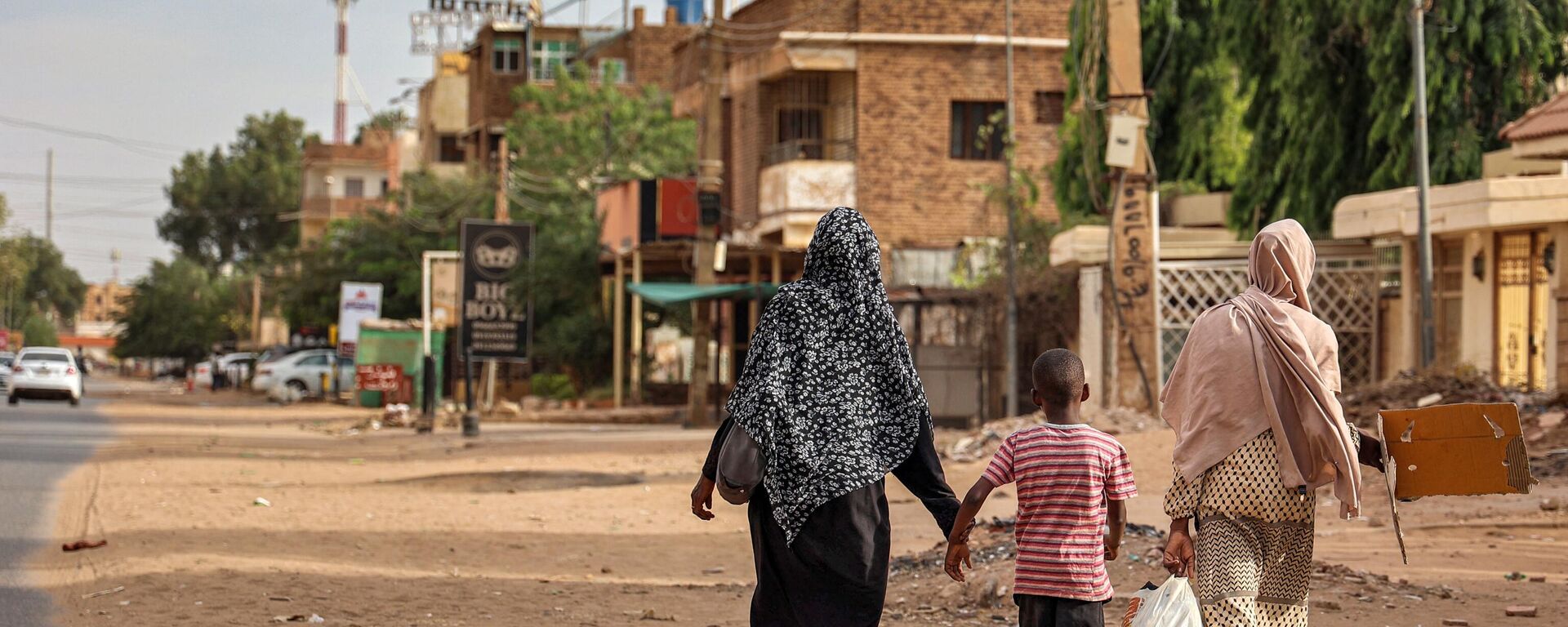 نساء وطفل يمشون على طول شارع في الخرطوم في 18 أبريل 2023 - سبوتنيك عربي, 1920, 28.04.2023