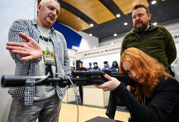 زائرة تحمل مدفعا رشاشا في المعرض المتخصص الثاني "إكيبيروفكا" في إحدى أجنحة  الحديقة العامة "في دي إن خا". - سبوتنيك عربي