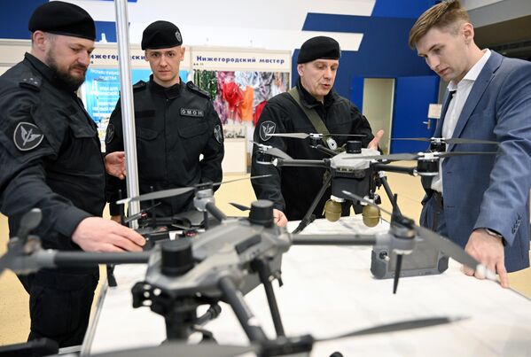 زوار يفحصون طائرات  كوادكوبتر (ذات المراوح الأربع) في المعرض المتخصص الثاني "إكيبيروفكا" في إحدى أجنحة  الحديقة العامة "في دي إن خا". - سبوتنيك عربي