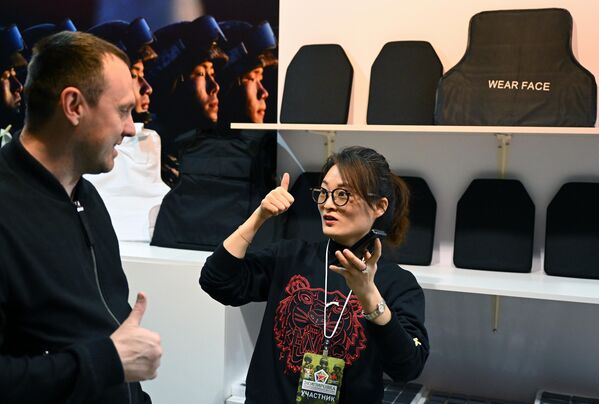 زائر يتحدث إلى مشاركة في المعرض المتخصص الثاني "إكيبيروفكا" في إحدى أجنحة  الحديقة العامة "في دي إن خا". - سبوتنيك عربي