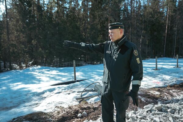 يشير العقيد في حرس الحدود الفنلندي ميكا ريتكونن في اتجاه الحدود الفنلندية الروسية في إيماترا بفنلندا، 14 أبريل 2023. - سبوتنيك عربي