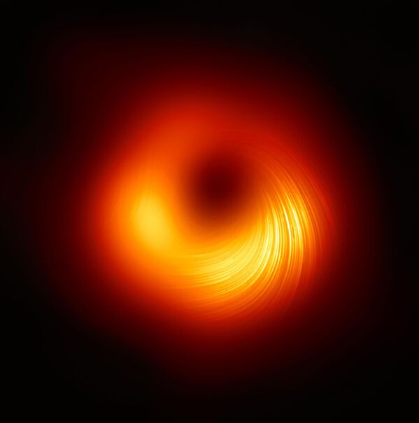 صورة مركبة بواسطة تلسكوب "إيفينت هورايزن" (Event Horizon Telescope)، الذي أنتج أول صورة على الإطلاق لثقب أسود تم إصداره في عام 2019، لديه اليوم رؤية جديدة للجسم الهائل في مركز مجرة "مسييه 87" (Messier 87): يُظهر كيف يبدو في الضوء المستقطب. هذه هي المرة الأولى التي يتمكن فيها علماء الفلك من قياس الاستقطاب، وهو علامة  المجالات المغناطيسية، قرب حافة ثقب أسود. تُظهر هذه الصورة المنظر المستقطب للثقب الأسود في مجرة M87. تحدد الخطوط اتجاه الاستقطاب المرتبط بالمجال المغناطيسي حول ظل الثقب الأسود. - سبوتنيك عربي