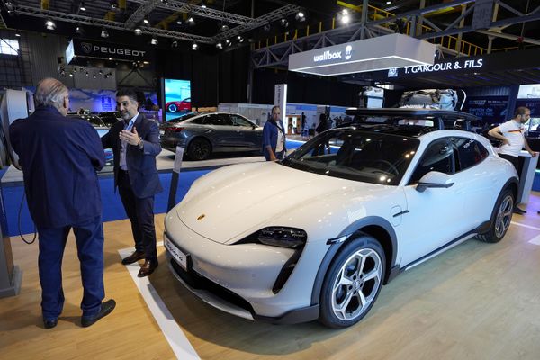 أشخاص يقفون بجانب سيارة Porsche Taycan الكهربائية الجديدة التي ستعرض في معرض e-Motor في بيروت، لبنان، 10 مايو 2023. - سبوتنيك عربي