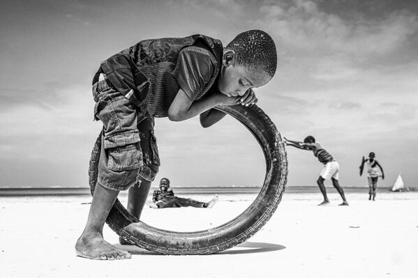 عنوان السفر الفردي: يوم معتاد في زنجبار صاحب الصورة: يانيتسا جينوفا (بلغاريا) كما يقول رولان بارت، التصوير يقتل الوقت. بالضبط هذه اللحظات من الحفاظ على الصورة، مقطع عرضي لما يحدث في الحياة اليومية، حاولت أن أنقلها في صوري. لتجميد هذا الشعور بالتدفق المستمر للسعادة والهدوء. يبقى الأسود والأبيض أنقى طريقة ممكنة للتأثير، لإيجاد الغياب في الوجود. تساعد الرؤية بالأبيض والأسود في اختيار الصور حتى لا تتعارض مع المنطق المرئي والدلالي العام. - سبوتنيك عربي