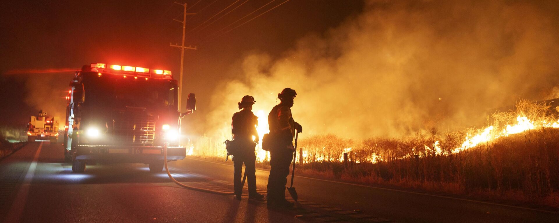 يراقب رجال الإطفاء النيران المشتعلة على طول طريق جيلمان سبرينغز أثناء حريق الأرنب في وقت متأخر من يوم 14 يوليو 2023  في مورينو فالي، ولاية كاليفورنيا الأمركية. - سبوتنيك عربي, 1920, 26.09.2023