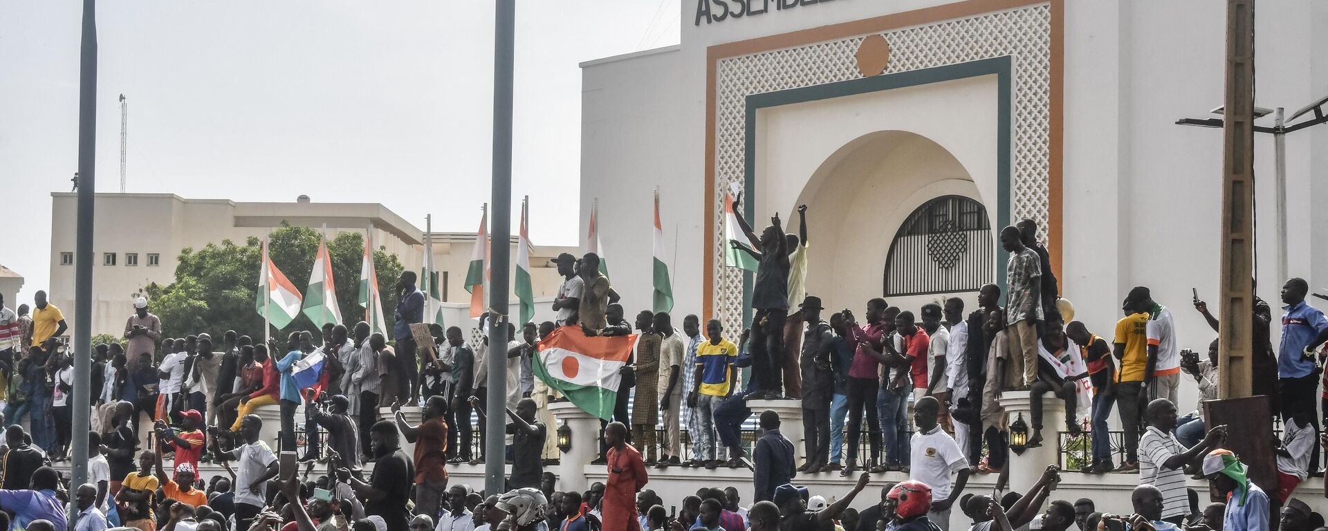 الوضع في النيجر -أنصار يلوحون بالأعلام النيجيرية أثناء احتشادهم لدعم المجلس العسكري النيجيري أمام مبنى الجمعية الوطنية في نيامي - سبوتنيك عربي, 1920, 02.09.2023