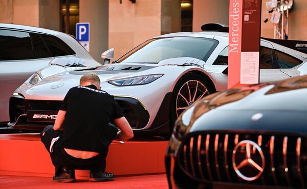 يضع العمال اللمسات النهائية على جناح "مرسيدس" بجانب سيارات Mercedes AMG في معرض ألمانيا الدولي للسيارات في ميونيخ، 4 سبتمبر 2023. - سبوتنيك عربي