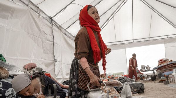 نساء يحضرن الشاي داخل خيمة أقيمت كمأوى مؤقت للناجين من الزلزال في قرية قريبة من أمزميز وسط المغرب في 13 سبتمبر 2023. - سبوتنيك عربي