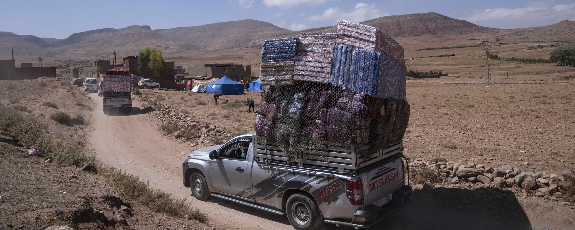 شاحنات تحمل مساعدات إنسانية تمر عبر قرية نائية تضررت من الزلزال، في بلدة دوزرو، خارج مراكش، المغرب، 13 سبتمبر 2023. - سبوتنيك عربي, 1920, 15.09.2023
