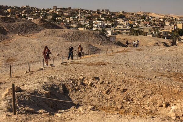 سياح يزورون موقع تل السلطان الذي يعود إلى ما قبل التاريخ بالقرب من مدينة أريحا الفلسطينية في الضفة الغربية في 17 سبتمبر 2023، والذي أضيف إلى قائمة التراث العالمي لمنظمة اليونسكو في اليوم نفسه. - سبوتنيك عربي