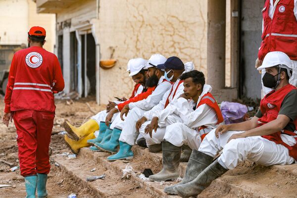 أعضاء فريق البحث والإنقاذ خلال استراحة في مدينة درنة، ليبيا 18 سبتمبر 2023 - سبوتنيك عربي