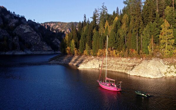 يخت في خليج كوزيريفسكي التابع لمستودع مياه يقع في منطقة نهر ينيسي، على خلفية صخور الحجر الجيري لموقع بيريوسينسكي الكارستية في إقليم كراسنويارسك الروسي. - سبوتنيك عربي