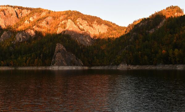 صخور وأشجار من الحجر الجيري تتلون بألوان الخريف أثناء غروب الشمس على شاطئ خليج بيريوسينسكي التابع لخزان كراسنويارسك، في منطقة نهر ينيسي في إقليم كراسنويارسك الروسي. - سبوتنيك عربي