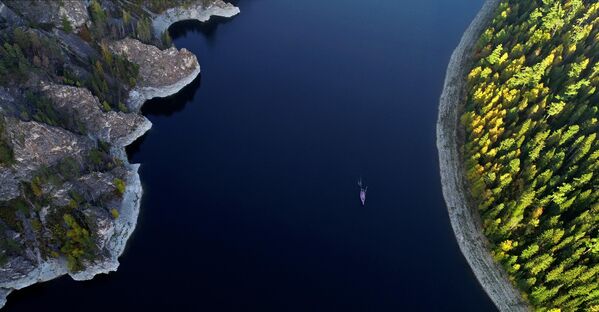 يخت في خليج كوزيريفسكي الواقع في مستودع مياه على نهر ينيسي، مع صخور الحجر الجيري بمحاذاة بيريوسينسكي الكارستية في التايغا الخريفية في إقليم كراسنويارسك الروسي. - سبوتنيك عربي