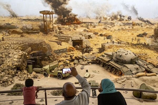 أشخاص يحضرون عرضًا لمشهد حرب تم إعادة إنشائه أثناء زيارة متحف بانوراما حرب السادس من أكتوبر والنصب التذكاري حرب 6 أكتوبر عام 1973 في القاهرة، مصر - سبوتنيك عربي
